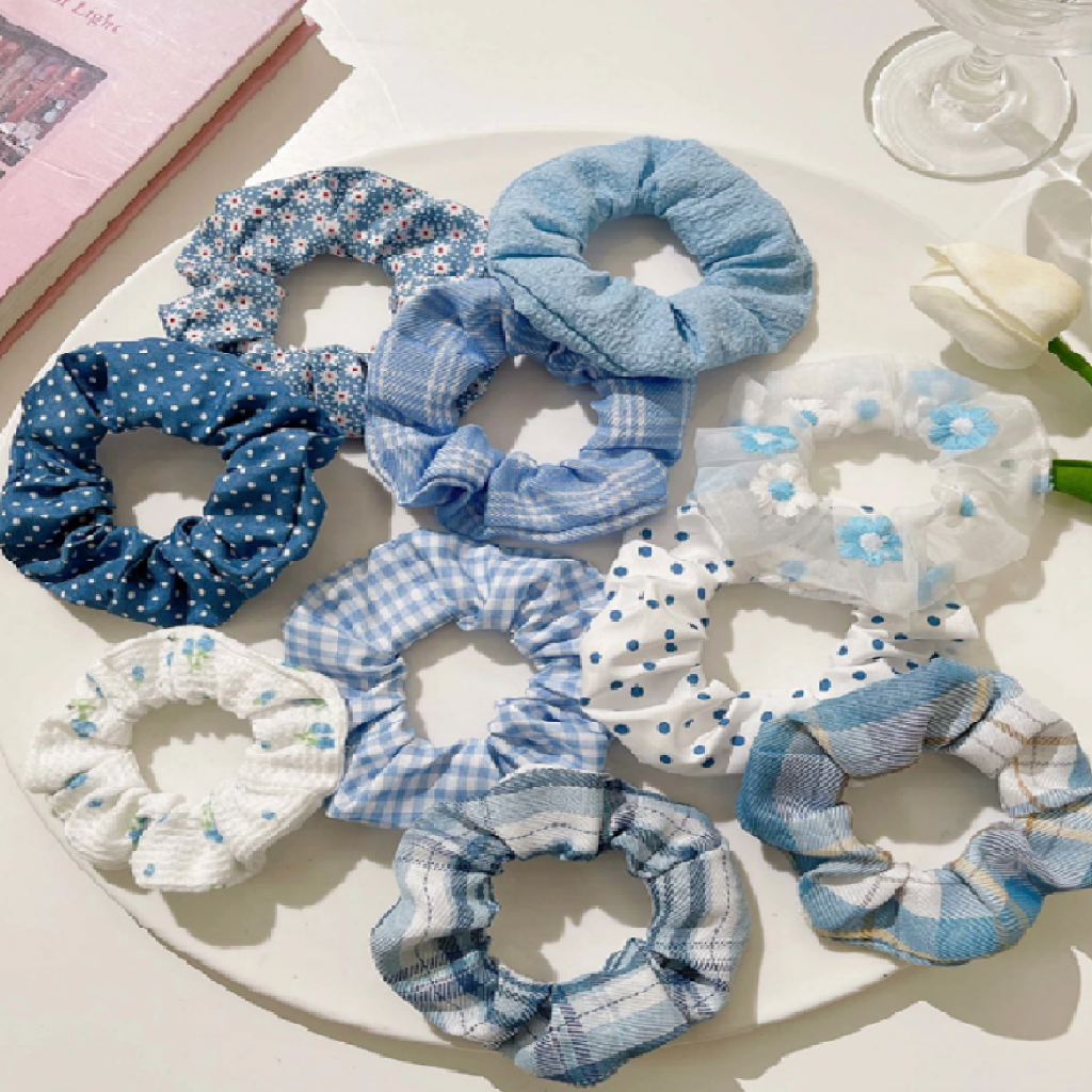Set of blue and white patterned scrunchies on a light surface.