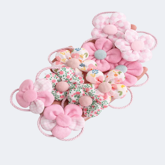 Set of pink floral hair accessories on a light gray background
