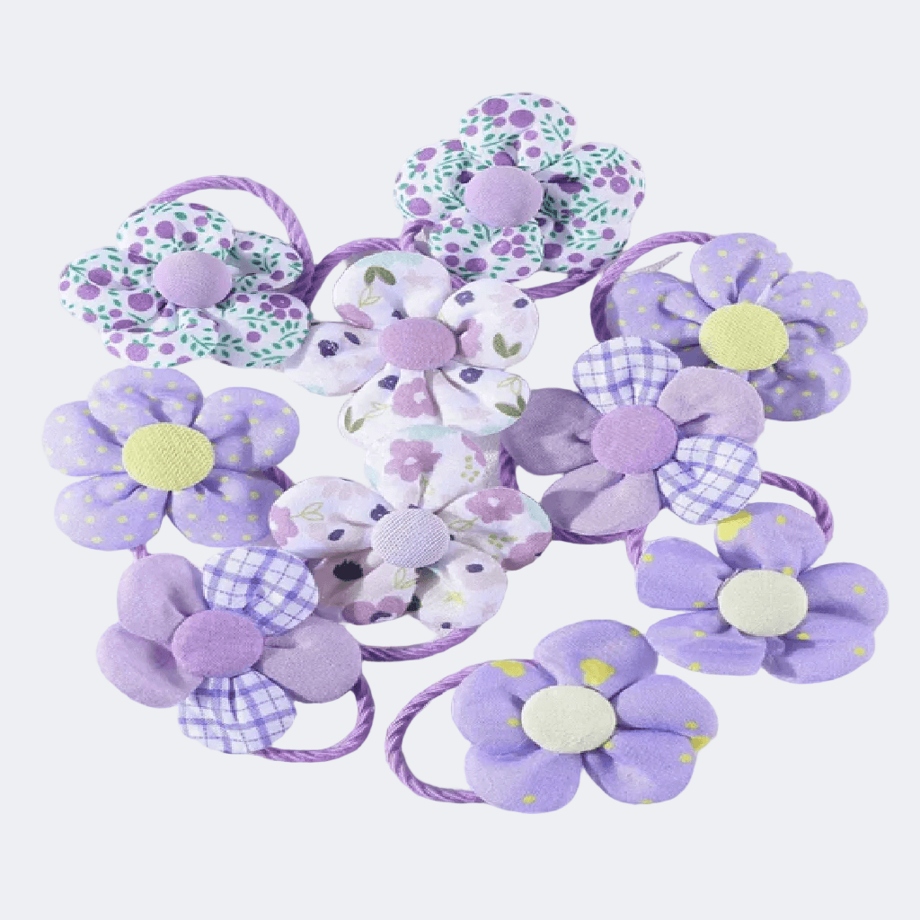 Set of purple flower-shaped hair ties on a white background