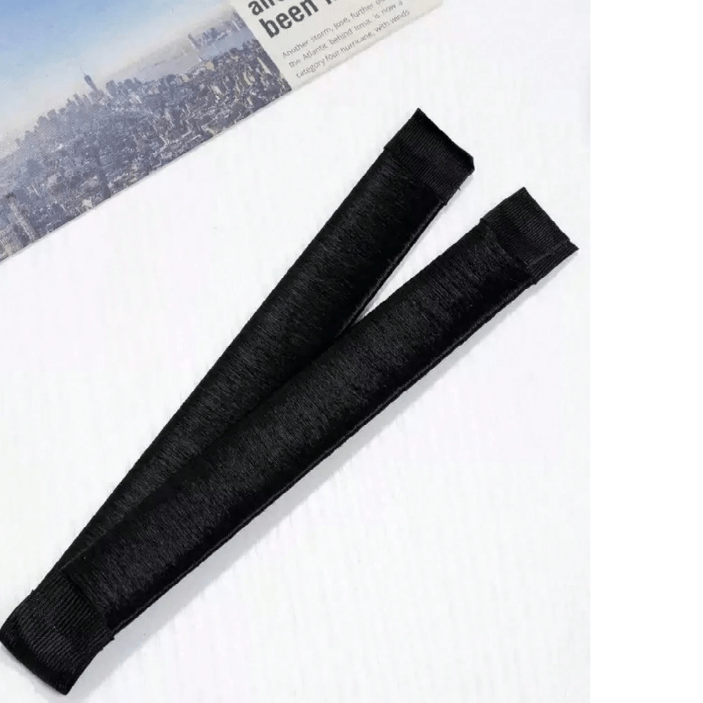 Two black hairnets on a white surface with a newspaper in the background.