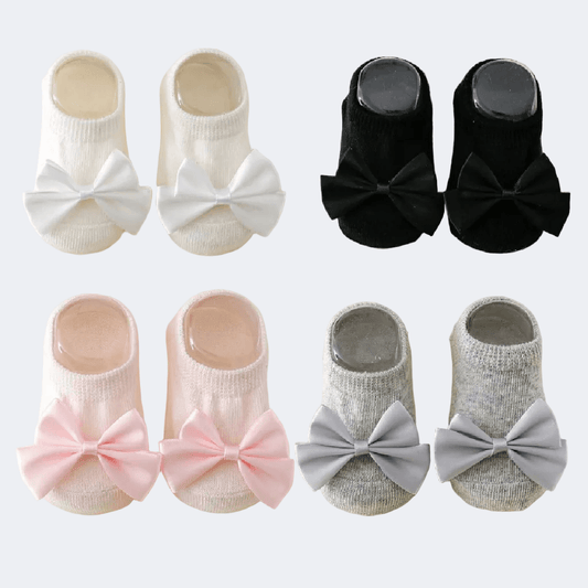 Set of baby socks with bow decorations in various colors on a white background