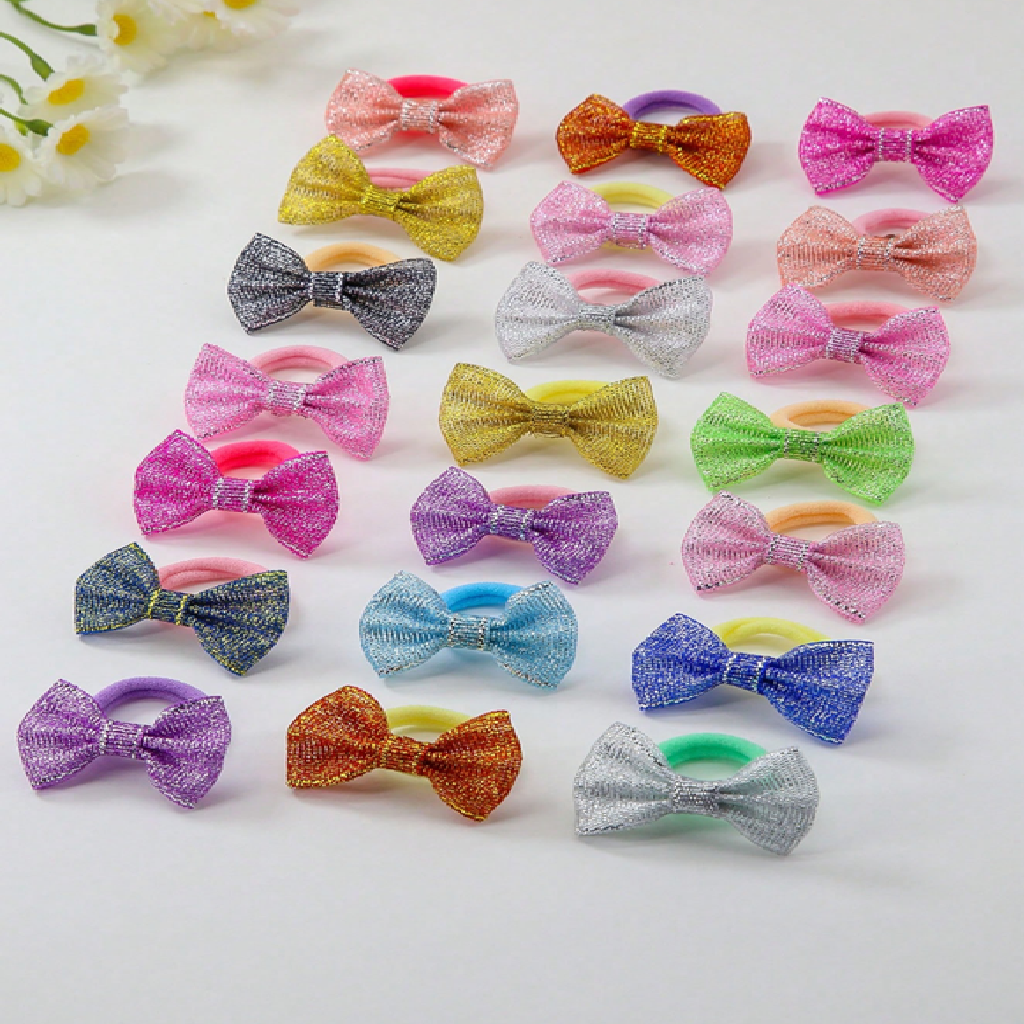 Assorted colorful glittery bow hair ties on a light background