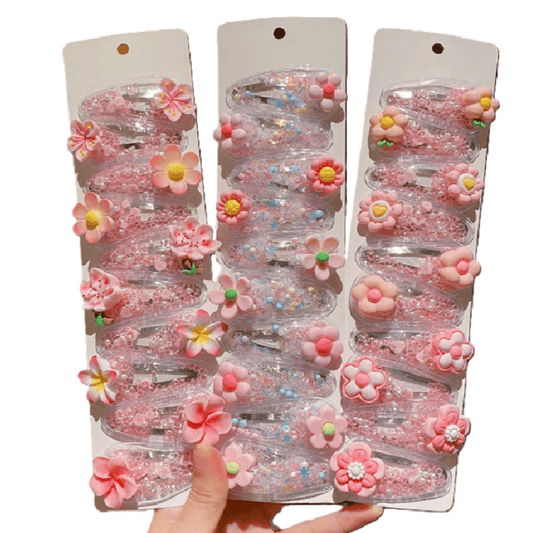 Three packages of pink flower-shaped hair clips held by a hand against a white background.
