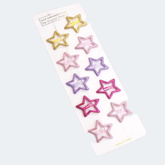Star-shaped hair clips in gold, pink, and purple on a white card.
