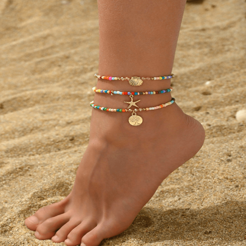 Anchors bracelet on a foot against a sandy background