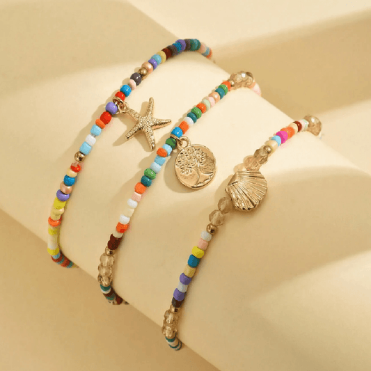 Anchors bracelet on a foot against a sandy background
