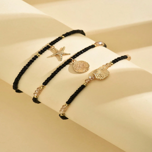 Black beaded bracelet with gold accents and shell charm