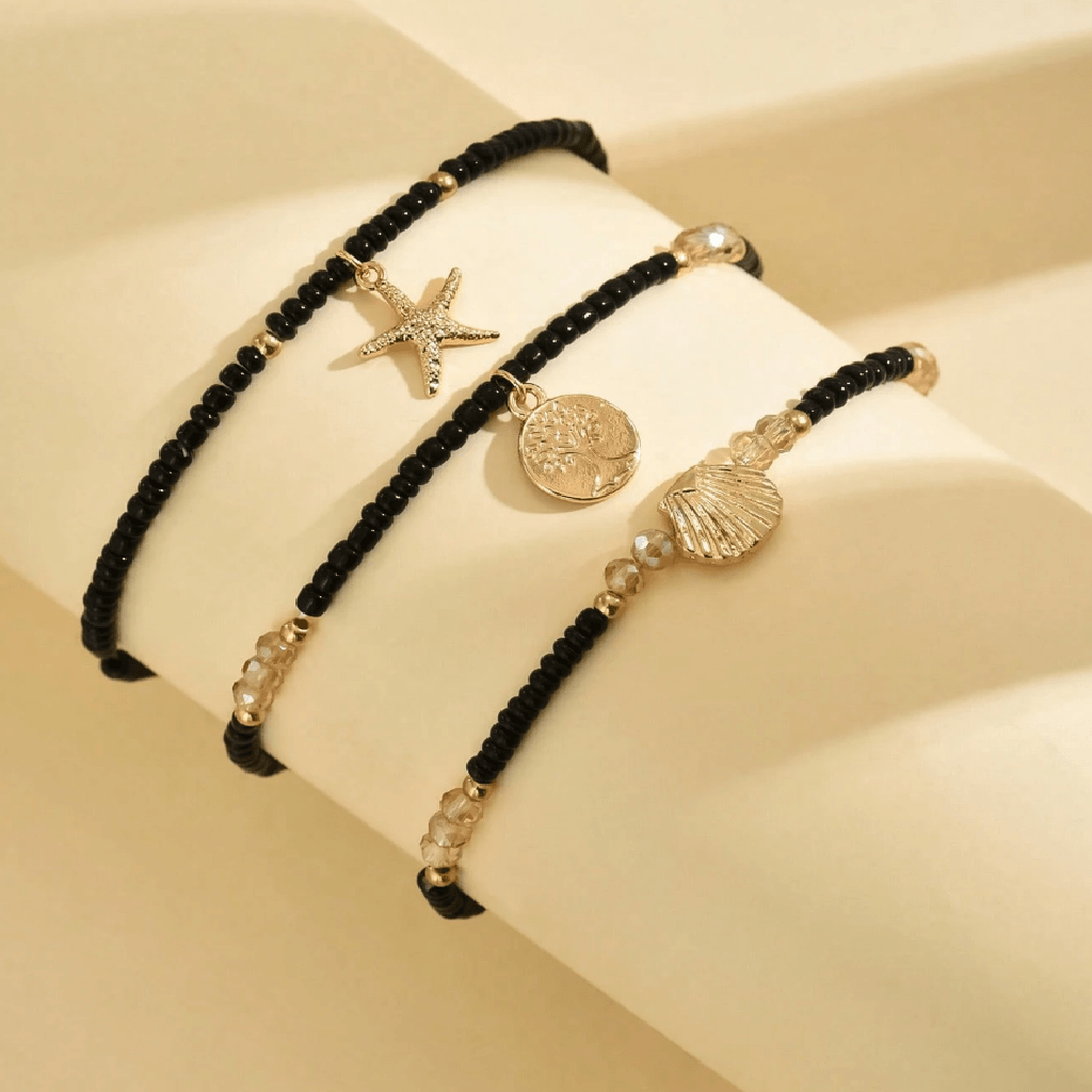 Ankle bracelet with star and shell charms on a sandy background