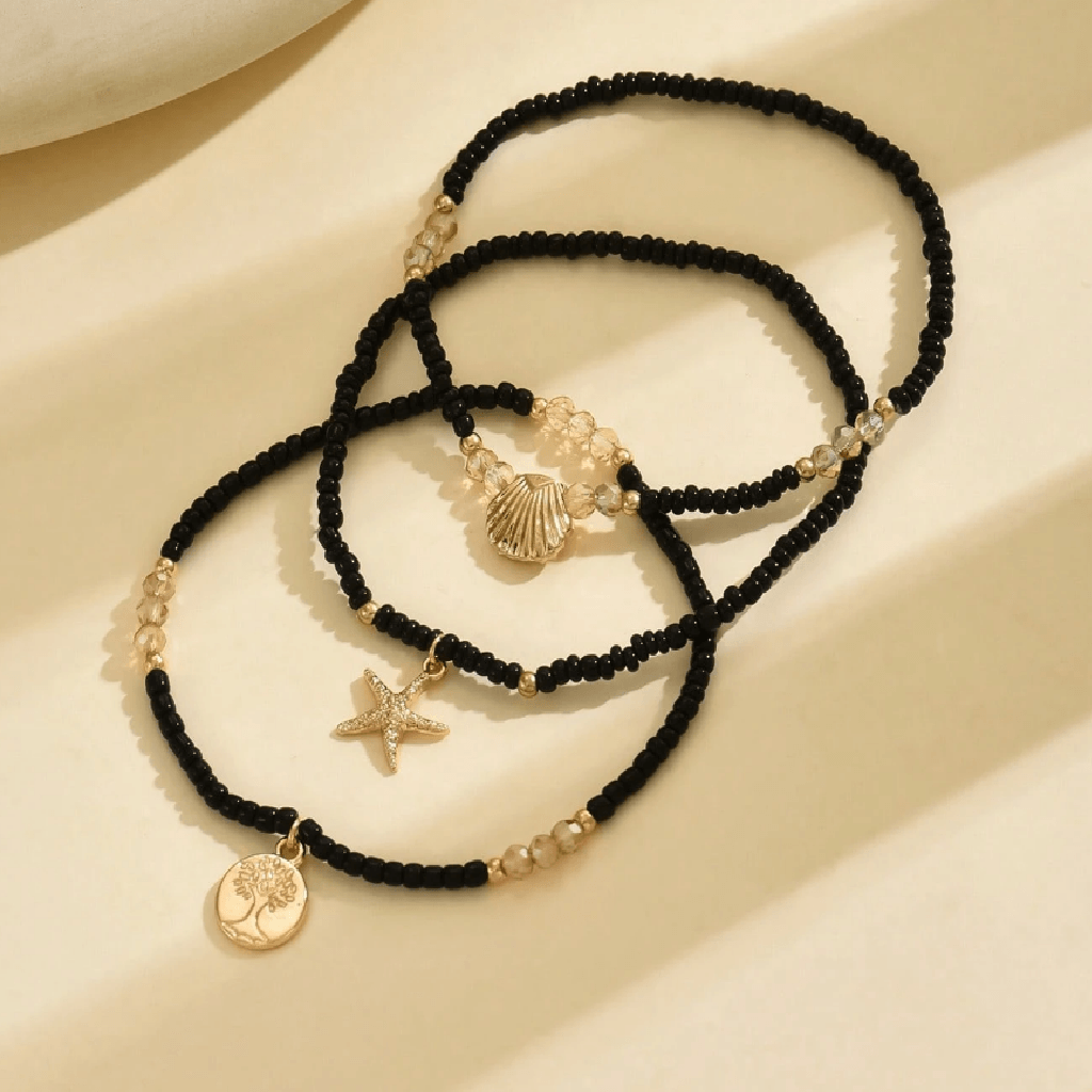 Ankle bracelet with star and shell charms on a sandy background