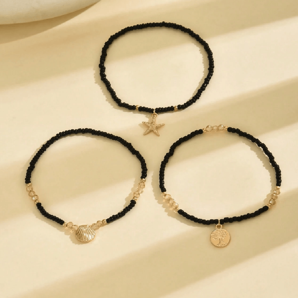 Ankle bracelet with star and shell charms on a sandy background