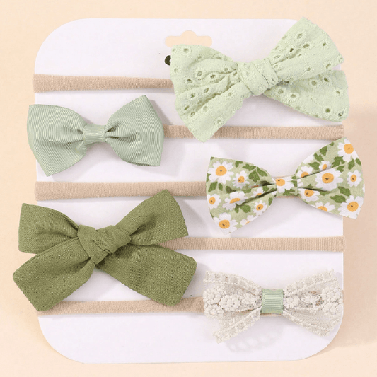 Set of five green-themed hair bows on a white background