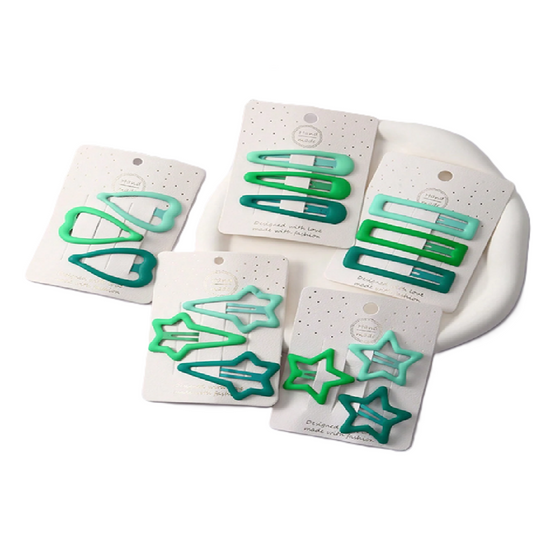 Set of green hair clips on white cards with a white background