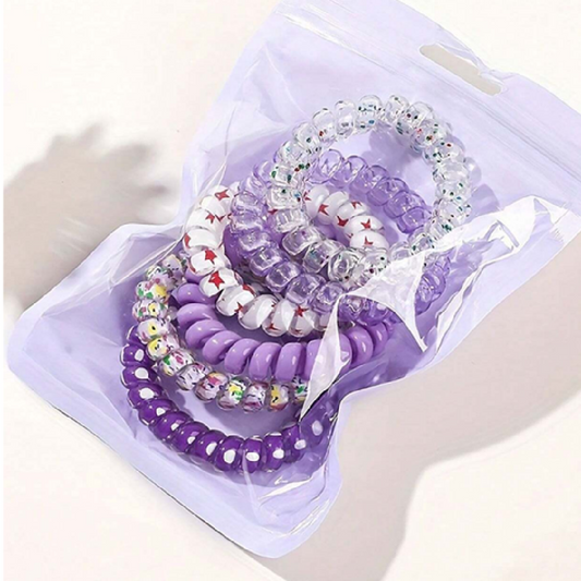 Set of beaded bracelets in purple and clear on a white background