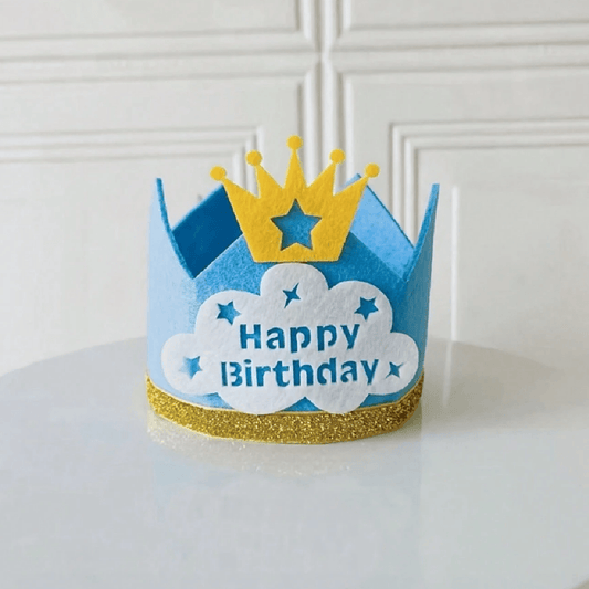 Blue birthday crown with yellow accents on a white surface