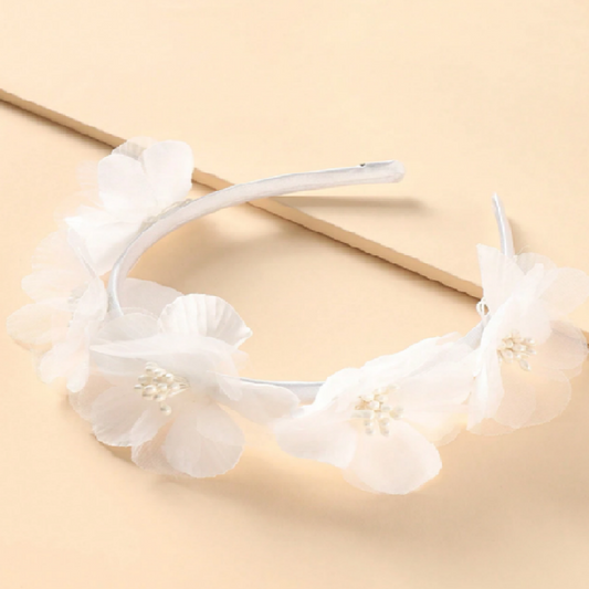 White floral headband on a beige background