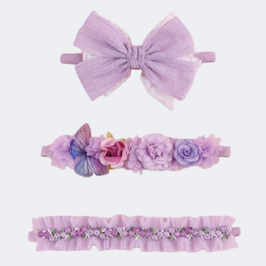 Set of three purple hair accessories including a large bow, floral headband, and decorative headband