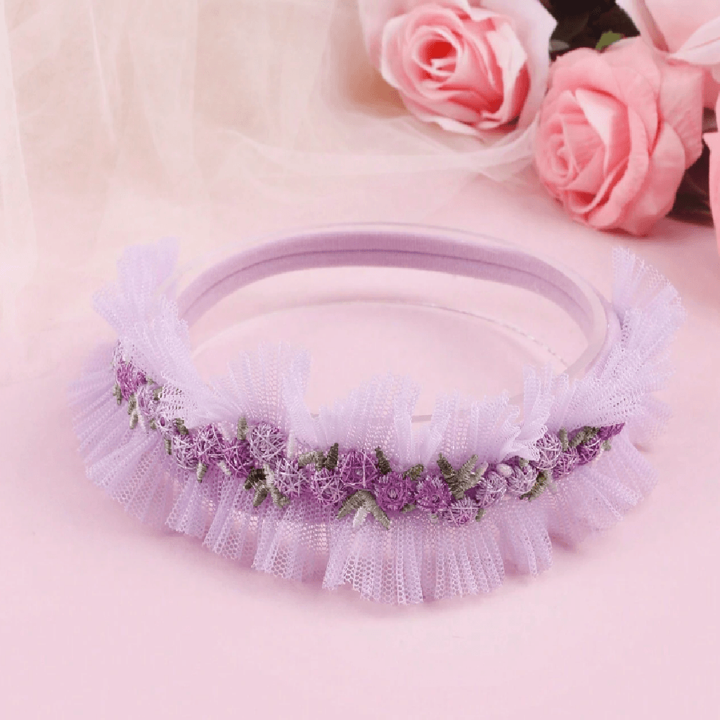 Purple headband with floral decorations on a pink background