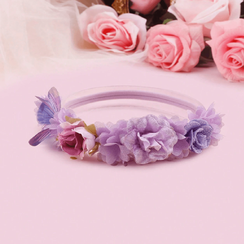 Purple headband with floral decorations on a pink background