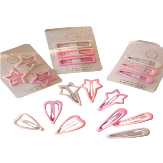 Set of pink hair clips on a light surface with packaging in the background.