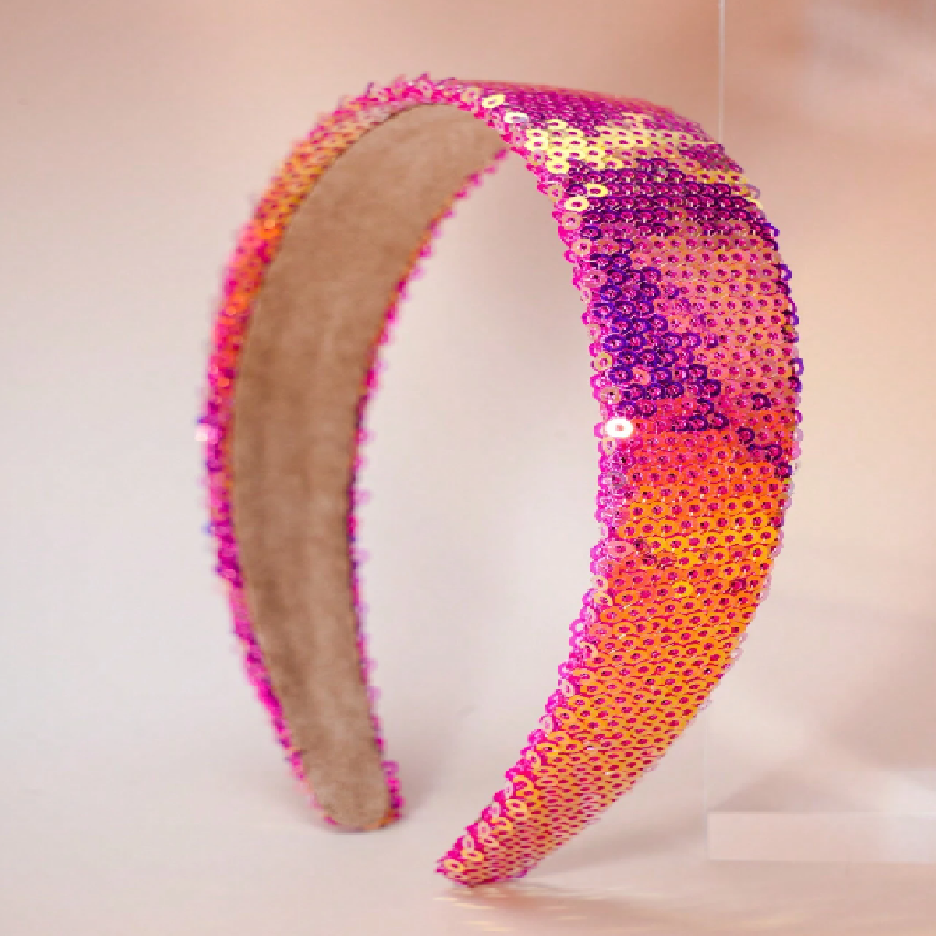 Sequined headband with pink and orange gradient on a beige background