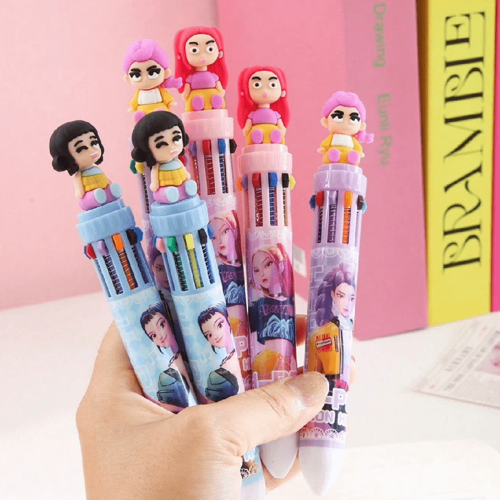 Colorful pens with cartoon characters held by a hand against a pink background