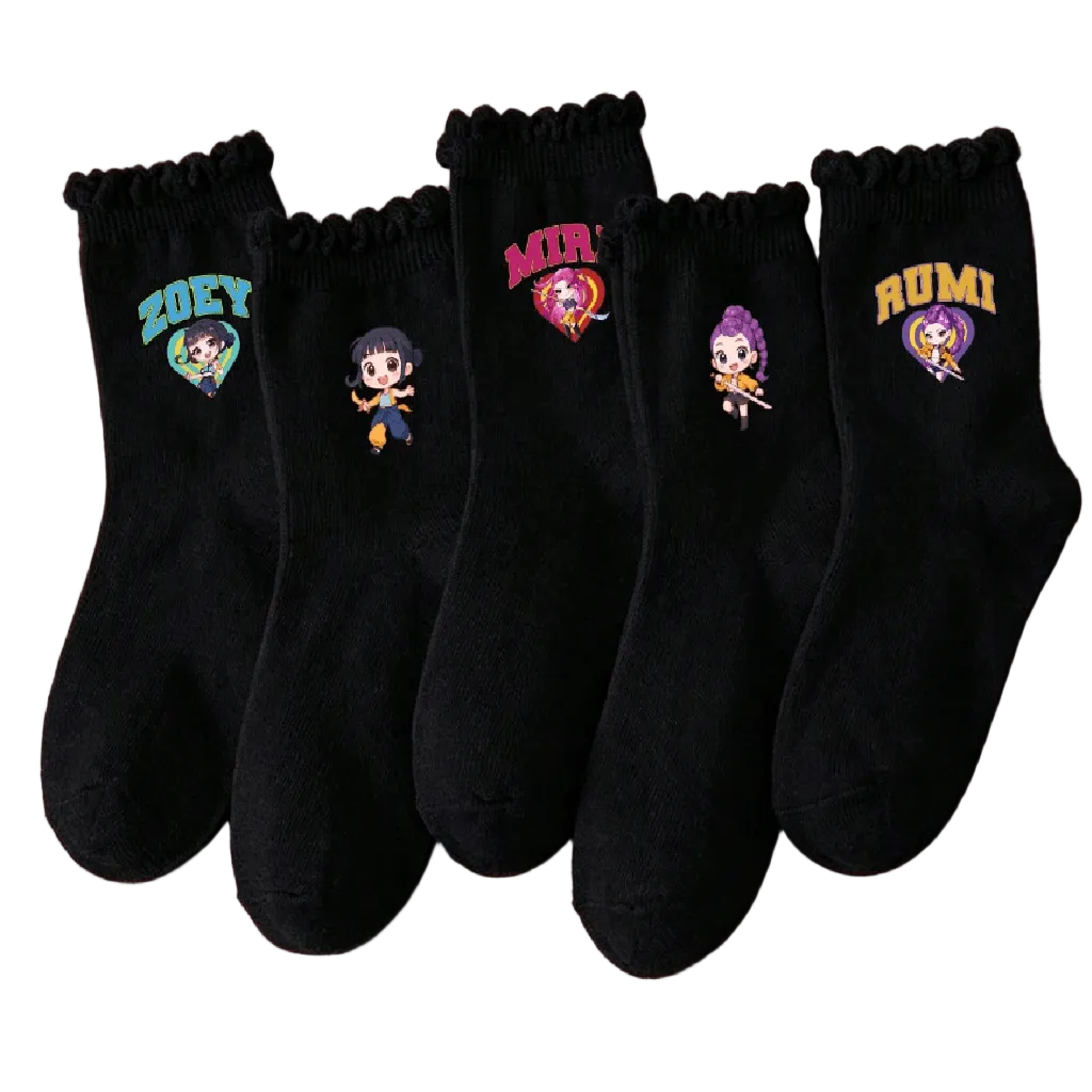 Five pairs of black crew socks with scalloped ruffle hems are arranged in a fan shape on a solid pink background. Each pair features a different colorful embroidered cartoon character.