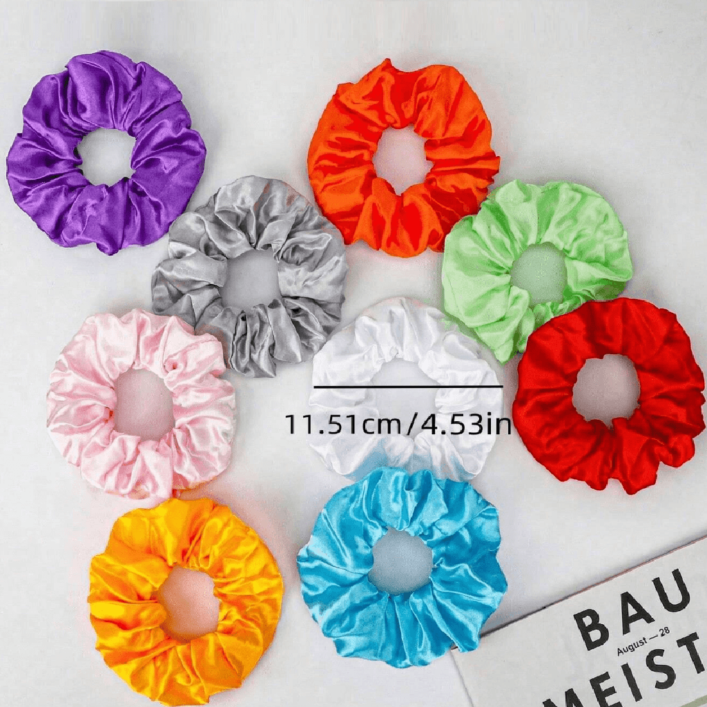 Colorful scrunchies on a white background with a ruler for size reference.