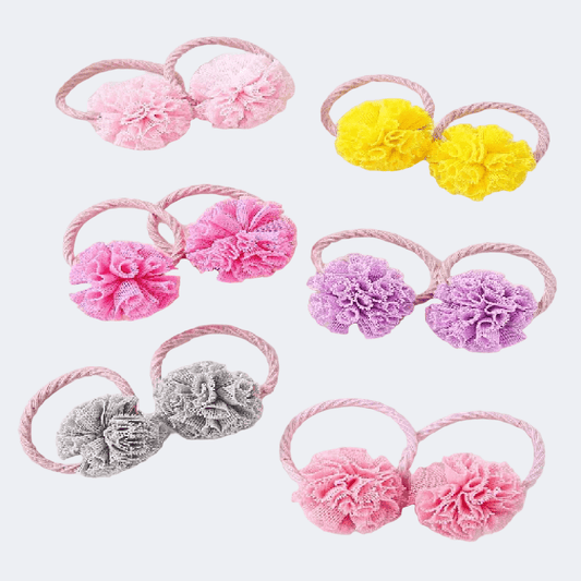 Set of colorful flower-shaped hair ties on a white background
