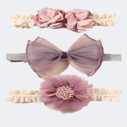 Three decorative headbands with flowers and bows on a light gray background