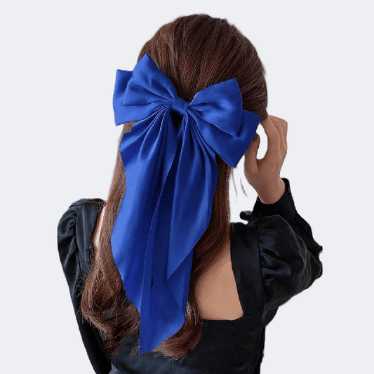 Person with a large blue bow in their hair against a white background