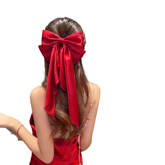 Woman wearing a large red bow in her hair on a white background