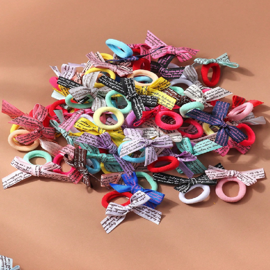 Assorted colorful hair ties with bows on a brown background