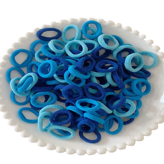 Blue and turquoise hair ties on a white plate