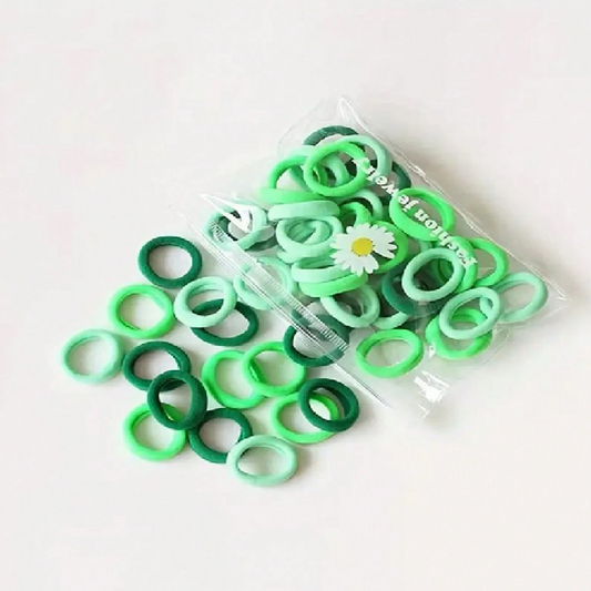 Green hair ties in a clear plastic bag on a white background