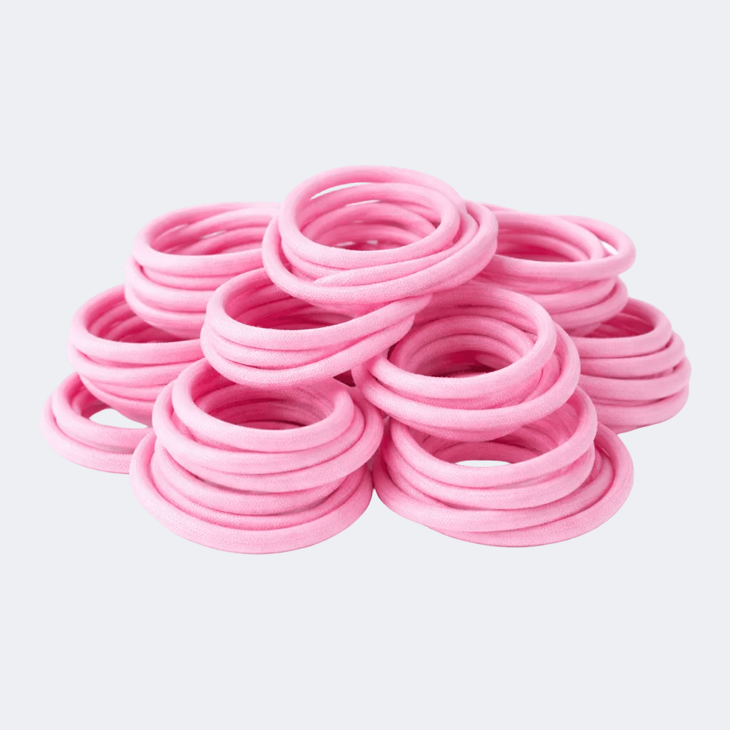 Stack of pink hair ties on a light gray background
