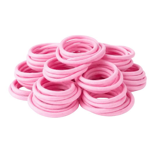Stack of pink hair ties on a light gray background