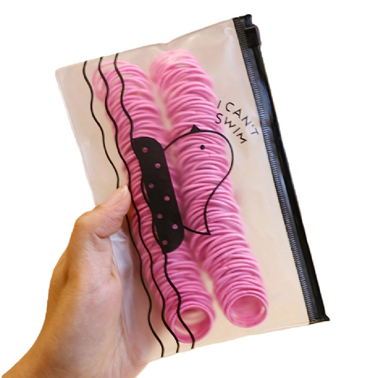 Hand holding a clear plastic bag with pink hair ties and 'I Can't Swim' text.