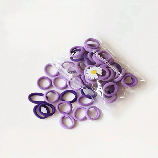 Purple hair ties with a clear plastic bag on a white background