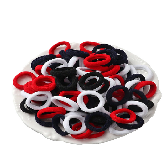 Assorted red, black, and white hair ties on a white plate
