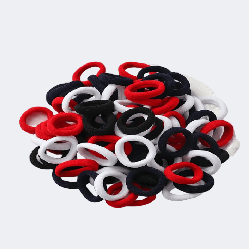 Assorted red, black, and white hair ties on a light gray background