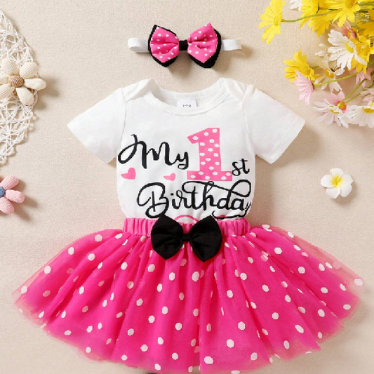 Baby outfit with pink polka dot dress and headband on a beige background