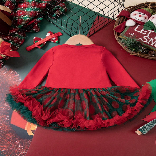 Red dress with green plaid skirt on a hanger against a festive background