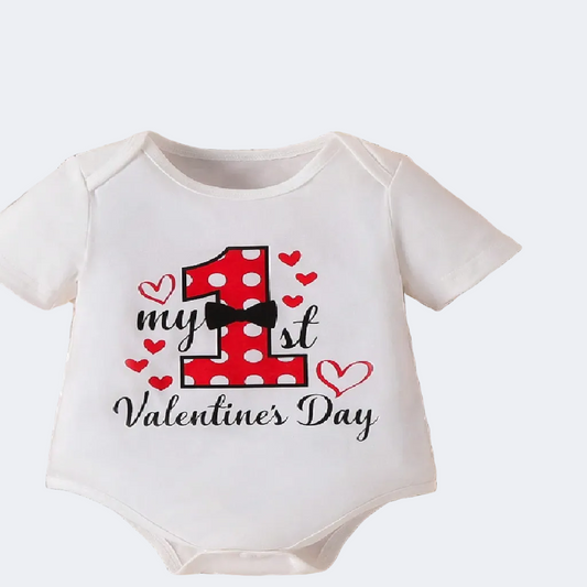 Baby onesie celebrating first Valentine's Day on a woven surface