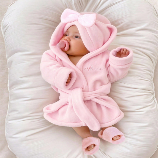 Baby wrapped in a pink robe with hat and slippers