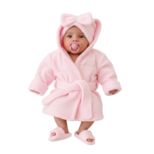 Baby wrapped in a pink robe with hat and slippers