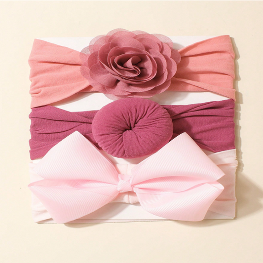 Set of three pink and purple headbands with floral and bow designs