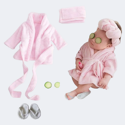 Baby in pink robe with accessories on a white background
