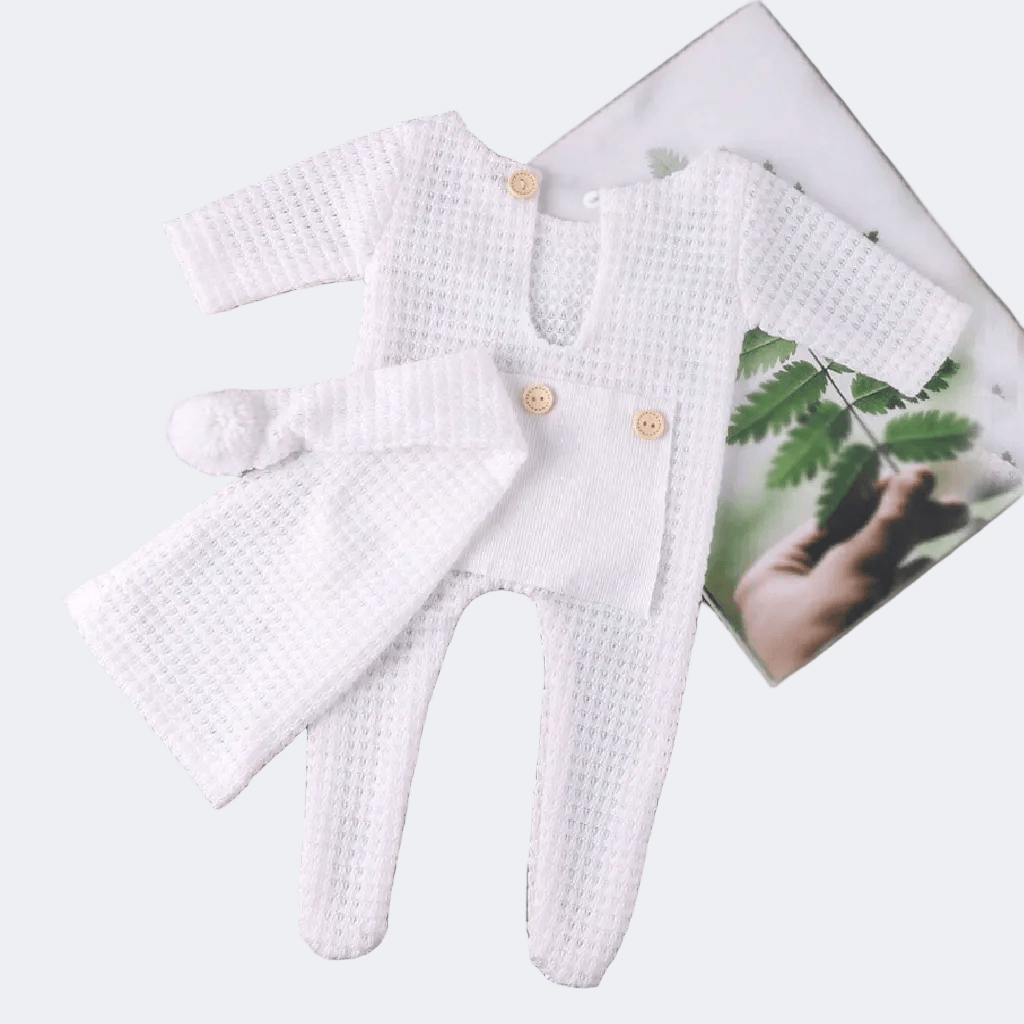 White baby romper with matching hat on a white background