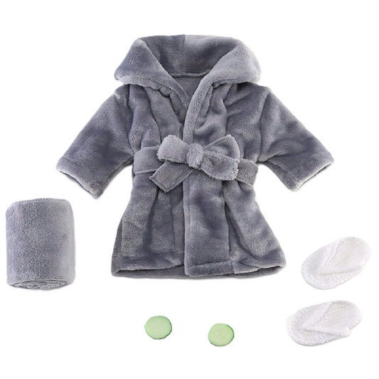 Gray plush robe with matching towel, washcloths, and bath bombs on a white background