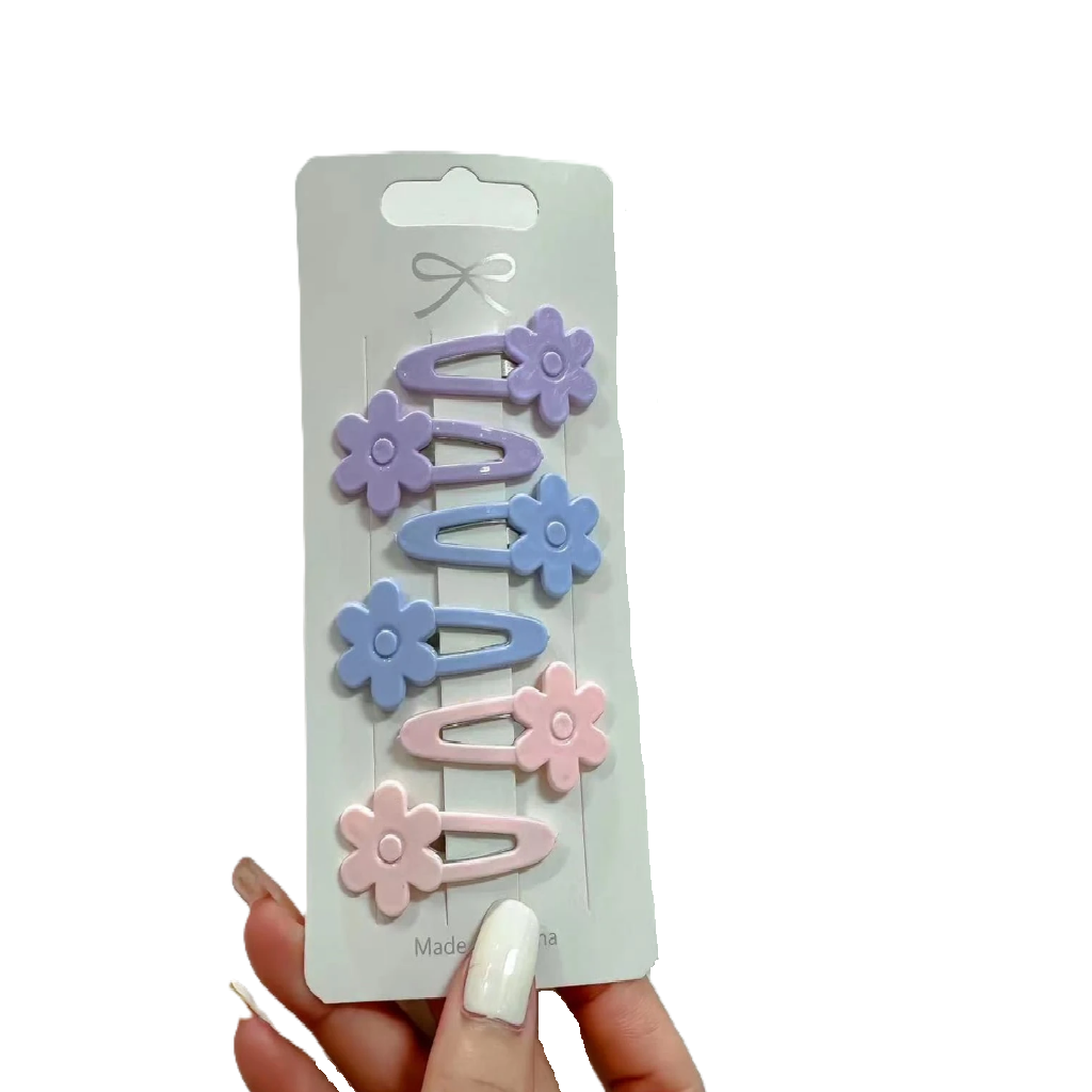 Set of pastel-colored flower-shaped hair clips on a branded card held by a hand.